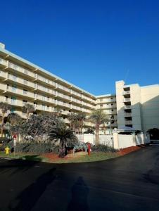 duży budynek apartamentowy z palmami przed nim w obiekcie Sandcastles Condominium Complex w mieście Cocoa Beach