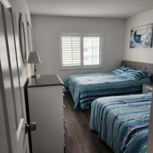 sypialnia z 2 łóżkami i oknem w obiekcie Sandcastles Condominium Complex w mieście Cocoa Beach
