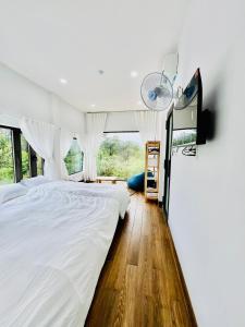 1 dormitorio con 1 cama grande con sábanas blancas en Măng Đen Land - Homestay&Coffee en Kon Von Kla