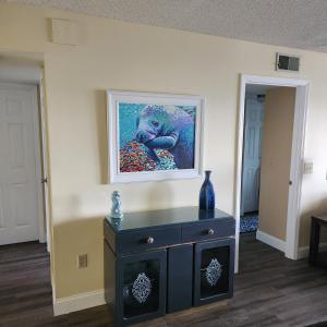 um quarto com uma pintura na parede e uma cómoda em Sandcastles Condominium Complex em Cocoa Beach