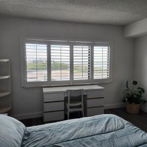 a bedroom with a bed and a desk and a window at Sandcastles Condominium Complex in Cocoa Beach