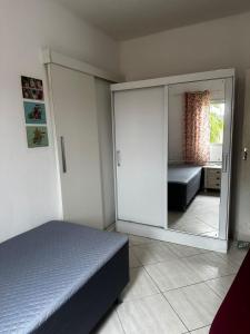 a bedroom with a bed and a large mirror at Casa Al Mare in Itanhaém +16 photos