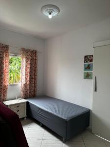 a bedroom with a bed and a window at Casa Al Mare in Itanhaém