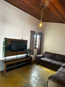Il comprend un salon doté d'un canapé et d'une télévision à écran plat. dans l'établissement Casa Al Mare, à Itanhaém