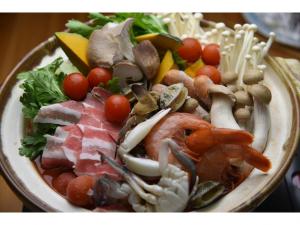 a bowl of food with seafood and vegetables on a table at ペンション イメージハウス in Hara +22 photos