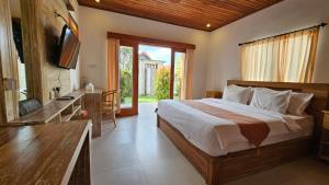 ein Schlafzimmer mit einem großen Bett und einem TV. in der Unterkunft Anzel Luxe Villa in Munggu