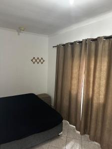 Un dormitorio con una cama y cortinas en una habitación. en Casa Al Mare, en Itanhaém 16 fotos más