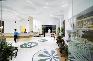 a lobby with people standing in a building at Palm Djerba Suites in Mezraya