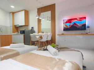 Habitación con 2 camas y mesa con sillas. en Just Chillin Pool & Seaview Suites en Kota Kinabalu