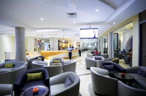 a lobby with couches and a tv in a building at Palm Djerba Suites in Mezraya