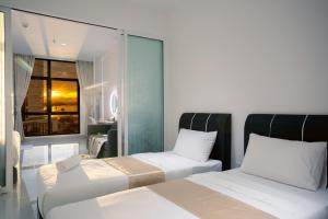 a hotel room with two beds and a window at Just Chillin Pool & Seaview Suites in Kota Kinabalu