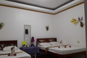 Habitación con 2 camas y espejo. en Hanbee's Resort en Puerto Princesa
