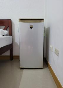 a small white refrigerator in a corner of a room at Hanbee's Resort in Puerto Princesa City