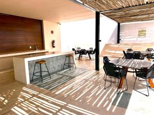 プラヤ・デル・カルメンにあるPaseo Luxury Houseのテーブルと椅子、バーが備わる客室です。