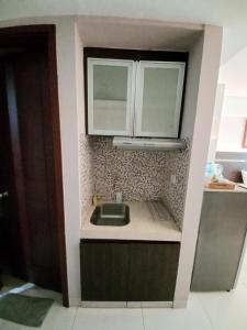 a small kitchen with a sink and two windows at The Cabin Mataram City in Kejayan