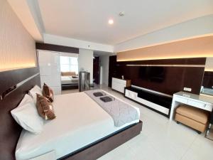 a large bedroom with a large bed and a kitchen at The Cabin Mataram City in Kejayan