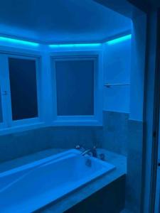 uma casa de banho com uma banheira branca e iluminação azul em 3BD 3BR CityView Central San Francisco -15 min walk from Castro station em São Francisco
