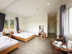 a hotel room with two beds and a table at Cherry Luxury Villa in Xuan An