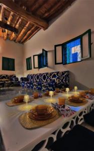 une table avec des assiettes et de la vaisselle en haut dans l'établissement Seventies Villa, à Sawdāʼ