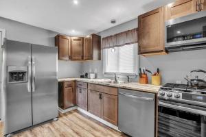 uma cozinha com armários de madeira e electrodomésticos de aço inoxidável em Park Place Suites em Buffalo
