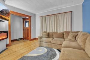 sala de estar con sofá y alfombra en Park Place Suites, en Buffalo