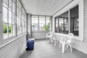 een veranda met een tafel, stoelen en ramen bij Park Place Suites in Buffalo