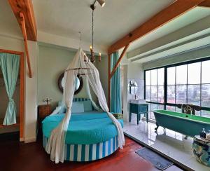 Schlafzimmer mit einem Bett, einer Badewanne und einer Badewanne in der Unterkunft Lacasa May in Da Lat
