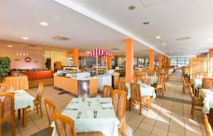 un comedor con mesas y sillas y un restaurante en Apartments in Umag - Istrien 11902 en Umag