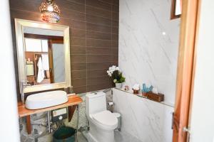 La salle de bains est pourvue de toilettes, d'un lavabo et d'un miroir. dans l'établissement แลภู ดูนา LaePhu DooNa Resort and Restaurant, à Ban San Pa Sak