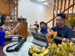 a woman taking a picture of a man playing a guitar at Lu Peaceful Homestay in Da Nang