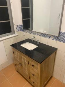 a bathroom with a sink and a mirror at Sandy Feet Cottage in Bargara +4 photos