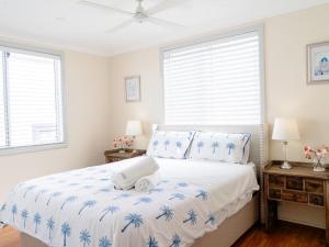 um quarto branco com uma cama com uma toalha em Amazing Views - 3 Bed Malabar em Sydney