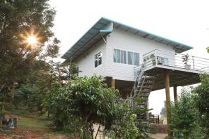 ein Haus mit einer Veranda und einer Treppe hinauf in der Unterkunft Family Hill Khaokho บ้านพัก กางเต็นท์ วิวภูเขา in Khao Kho