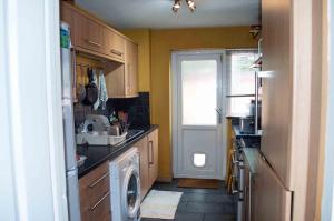 eine Küche mit einer Waschmaschine und einem Fenster in der Unterkunft Quiet 2 Bedroom house for holiday let in Gravesend in Kent