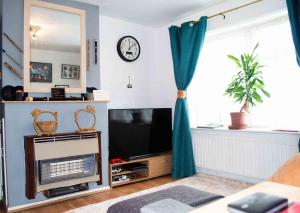 ein Wohnzimmer mit einem TV und einem Fenster in der Unterkunft Quiet 2 Bedroom house for holiday let in Gravesend in Kent