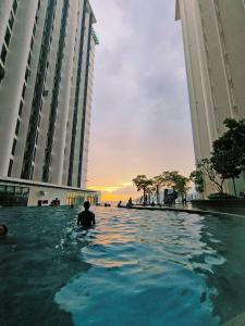 a person sitting in a swimming pool between two buildings at Just Chillin Pool & Seaview Suites in Kota Kinabalu