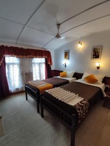 1 dormitorio con 2 camas y 2 ventanas en Kalappura Houseboats & Tours, en Alleppey