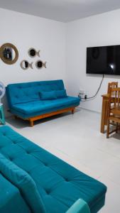 un sofá azul en la sala de estar con TV en Pipa Céu Azul, en Pipa
