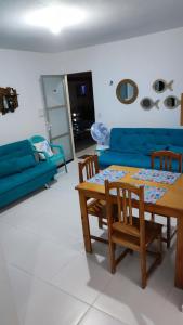 sala de estar con mesa y sofá azul en Pipa Céu Azul, en Pipa