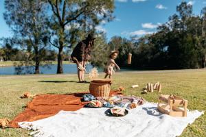 a man and a child sitting on a picnic blanket at Mercure Gold Coast Resort in Gold Coast
