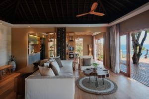 ein Wohnzimmer mit einem Sofa und einem Tisch in der Unterkunft TUNAK Resort Lombok in Bumbang