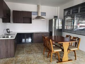 cocina con mesa, sillas y nevera en Baan Sabaijai Viking Home en That Phanom