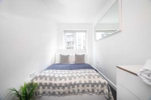 a bedroom with a bed in a white room at 3BR Apartment Ideal for 6, Near London Museums in Colindale