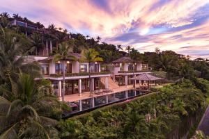 een luchtzicht op een huis op een heuvel met palmbomen bij Andara Resort Villas in Kamala Beach
