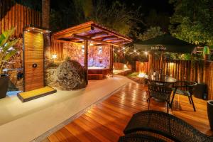 a patio with a table and a wooden floor at Chalés Araucária e Manacá in São Bento do Sapucaí