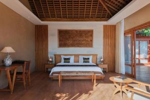 una camera con letto, tavolo e sedie di TUNAK Resort Lombok a Bumbang Altre 37 foto