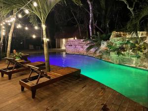 a pool with two lounge chairs next to a resort at Xoot Kaana Villa Vista Laguna in Bacalar +9 photos