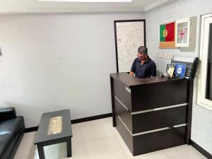 a man standing at a counter in a waiting room at Safa Homestay in Yogyakarta