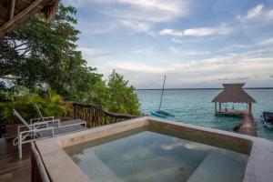 a swimming pool on a deck next to the ocean at Xoot Kaana Villa Vista Laguna in Bacalar