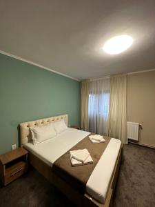 um quarto com uma cama grande e uma janela em Freedom&Relax em Buzău